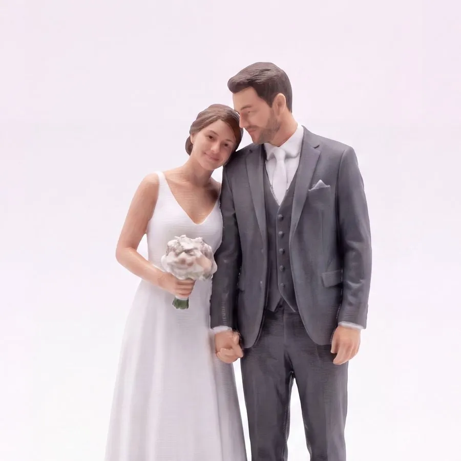 A hand-finished wedding cake topper of a bride and groom